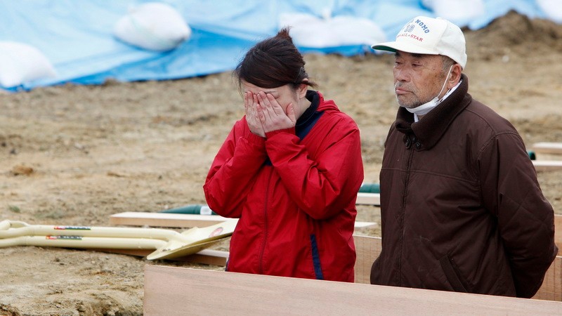 Japonsko, obete, dievčina plače, vedľa straší muž